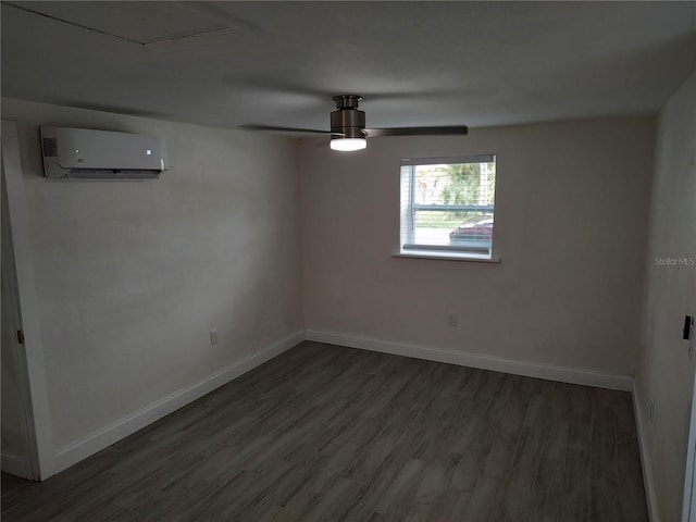 spare room with ceiling fan, a wall unit AC, wood finished floors, and baseboards