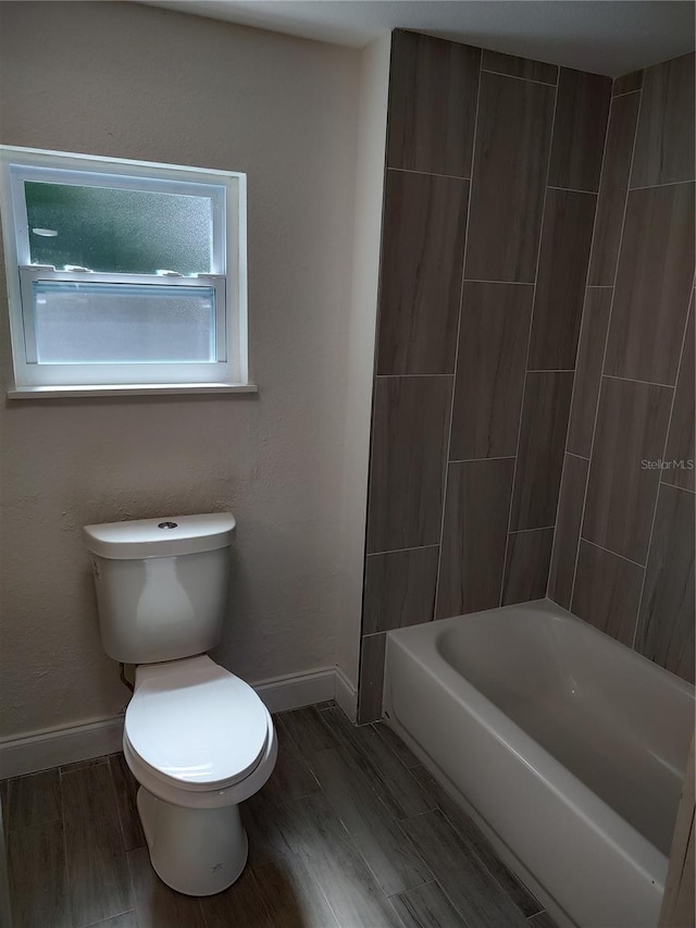 full bath with toilet, baseboards, and wood finished floors