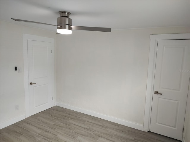 unfurnished room featuring a ceiling fan, wood finish floors, and baseboards