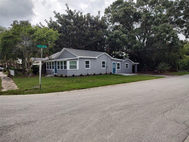 view of front of home with fence and a front lawn