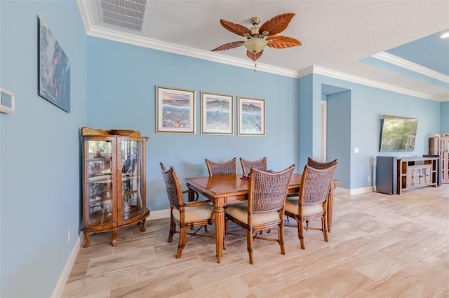 dining space with ornamental molding, visible vents, baseboards, and a ceiling fan