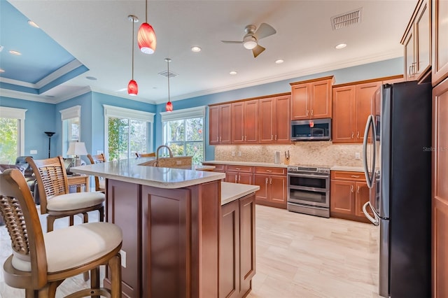 kitchen with brown cabinetry, visible vents, appliances with stainless steel finishes, and light countertops