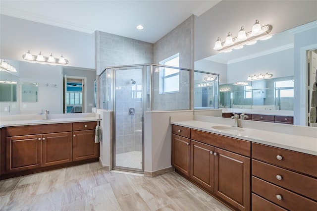 bathroom with ornamental molding, a stall shower, and a sink