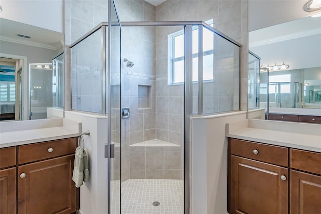 full bathroom with a stall shower, visible vents, crown molding, and vanity