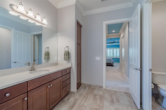 bathroom featuring baseboards, toilet, ensuite bathroom, crown molding, and vanity