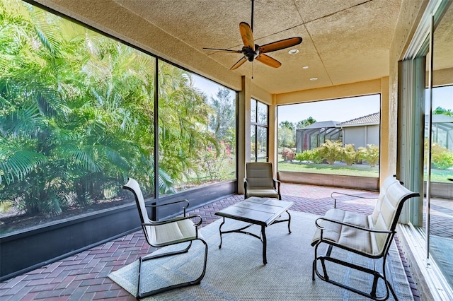 unfurnished sunroom featuring plenty of natural light and a ceiling fan