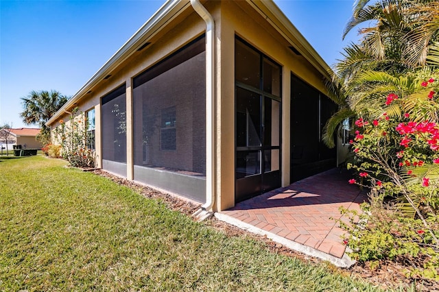 view of property exterior featuring a lawn and a sunroom