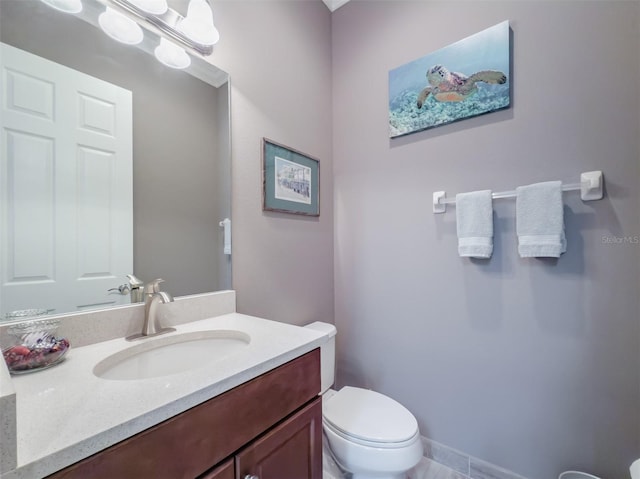 bathroom with toilet, baseboards, a notable chandelier, and vanity