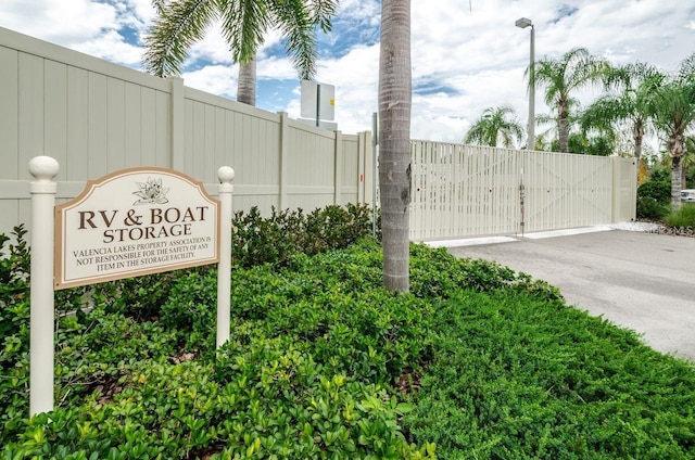 community sign featuring a gate and fence