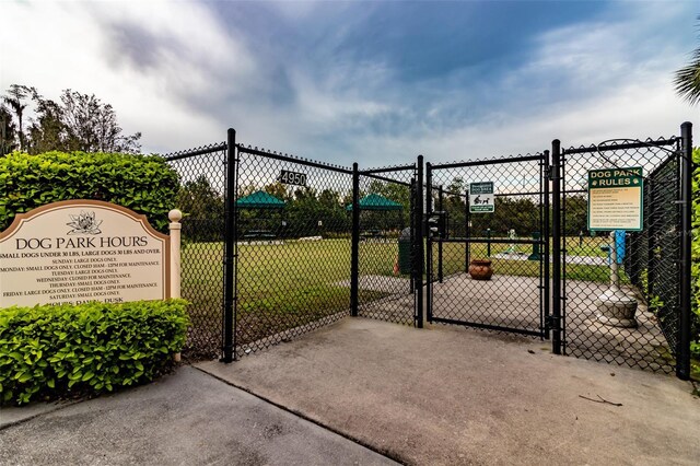 view of gate with fence and a lawn