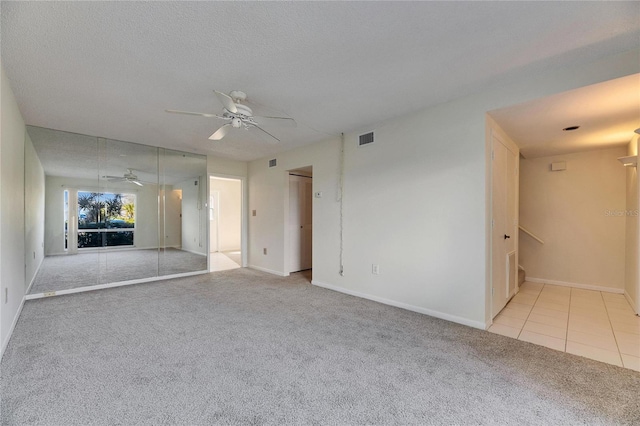 carpeted empty room with a textured ceiling and ceiling fan