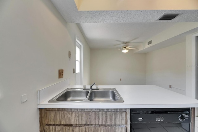 kitchen with sink, a textured ceiling, black dishwasher, and ceiling fan