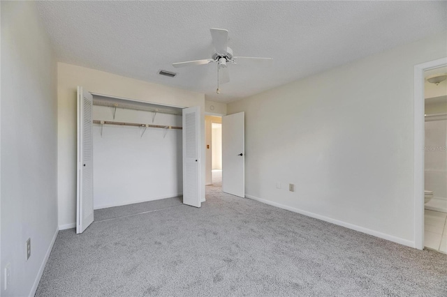 unfurnished bedroom with a closet, light carpet, and a textured ceiling