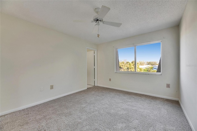 carpeted spare room featuring ceiling fan and a textured ceiling