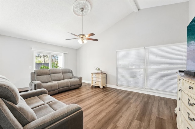 living room with beamed ceiling, ceiling fan, a textured ceiling, high vaulted ceiling, and hardwood / wood-style floors