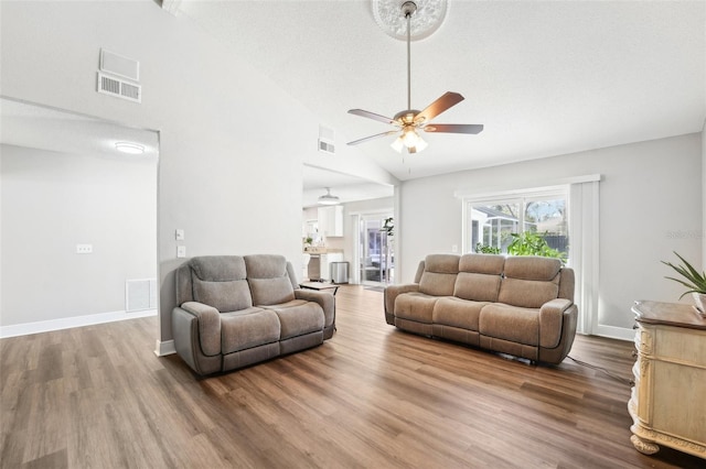 living room featuring a textured ceiling, high vaulted ceiling, hardwood / wood-style floors, and ceiling fan