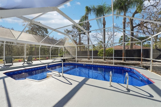 view of pool with glass enclosure and a patio