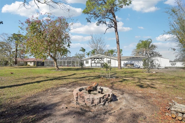 view of yard featuring glass enclosure and a fire pit