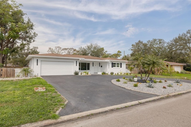 ranch-style house with a garage and a front lawn