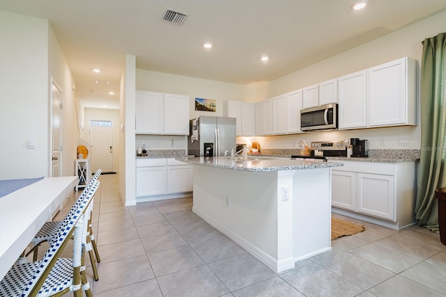 kitchen with an island with sink, appliances with stainless steel finishes, and white cabinets