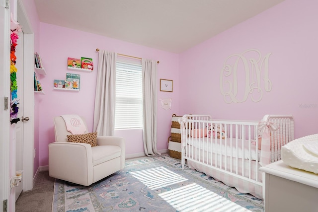 carpeted bedroom featuring a crib