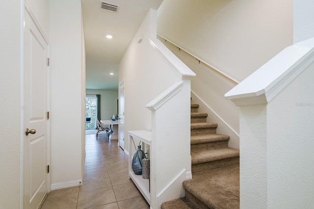 stairway featuring tile patterned flooring