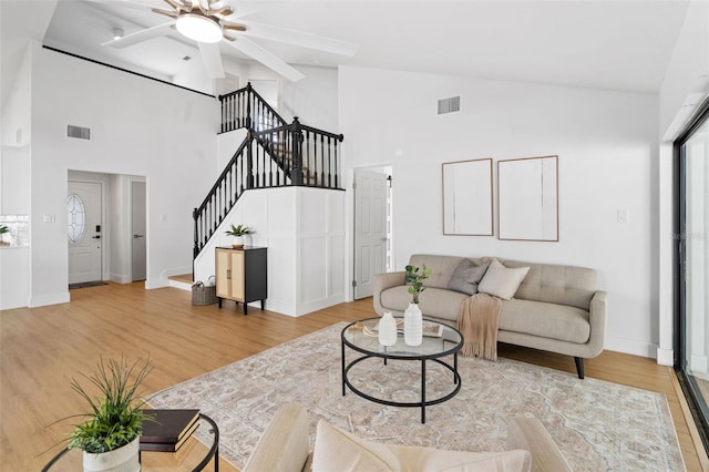 living room featuring hardwood / wood-style flooring, high vaulted ceiling, and ceiling fan