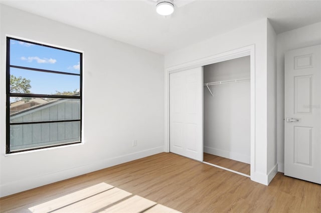 unfurnished bedroom with a closet and light wood-type flooring