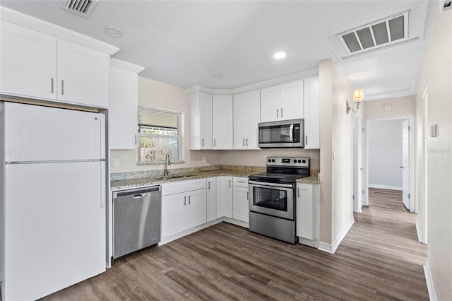 kitchen with white cabinetry, stainless steel appliances, dark hardwood / wood-style floors, and sink