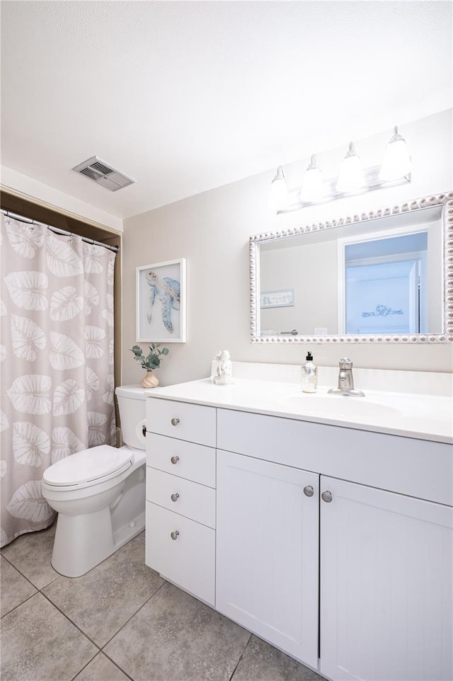 bathroom featuring vanity, tile patterned floors, and toilet