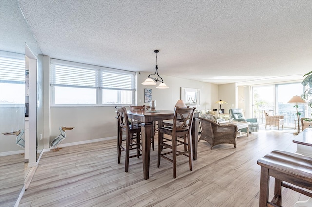 dining area featuring a textured ceiling and light wood-type flooring