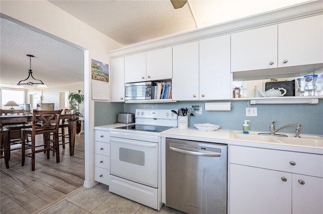 kitchen with appliances with stainless steel finishes, pendant lighting, sink, white cabinets, and a textured ceiling