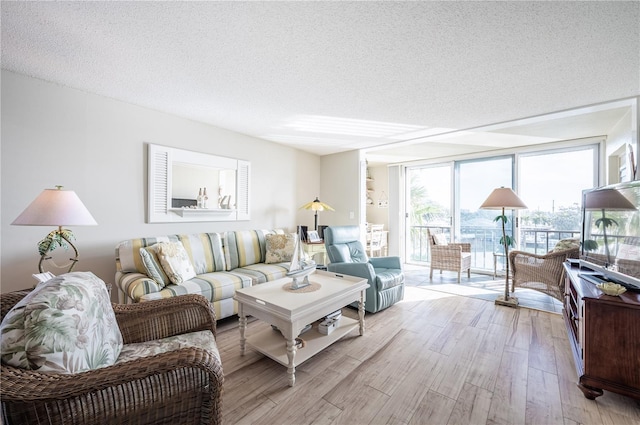 living room with floor to ceiling windows, a textured ceiling, and light hardwood / wood-style flooring