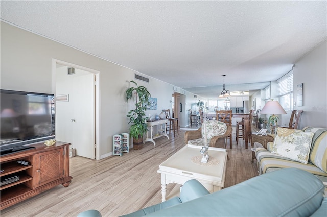 living room featuring a textured ceiling and light wood-type flooring