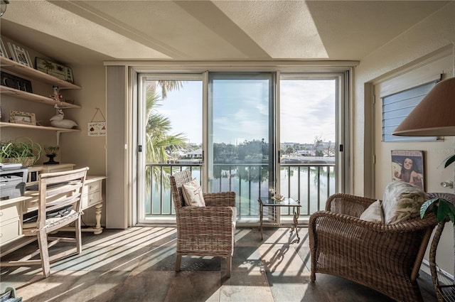 interior space featuring a water view, a textured ceiling, and a wealth of natural light