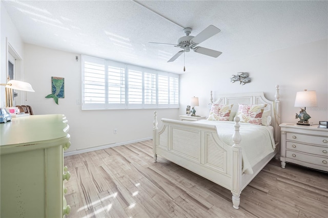 bedroom with ceiling fan, light hardwood / wood-style floors, and a textured ceiling