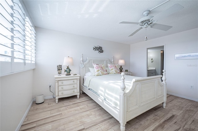 bedroom featuring ceiling fan, connected bathroom, a textured ceiling, and light wood-type flooring