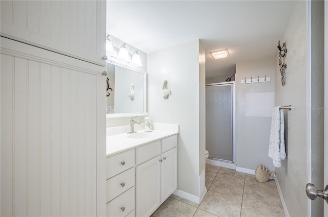 bathroom featuring tile patterned floors, toilet, a shower with door, and vanity