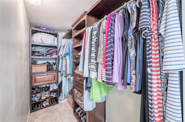 walk in closet with light tile patterned floors