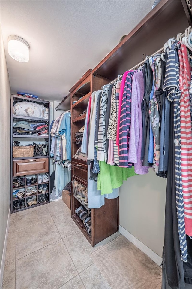 spacious closet with light tile patterned floors