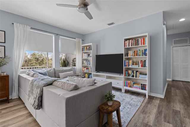 living room with wood-type flooring and ceiling fan