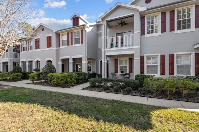 view of property with ceiling fan and a front yard