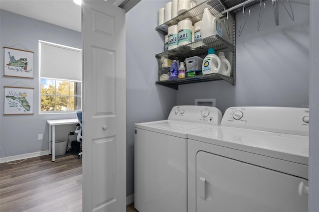 laundry area with washing machine and clothes dryer and light wood-type flooring