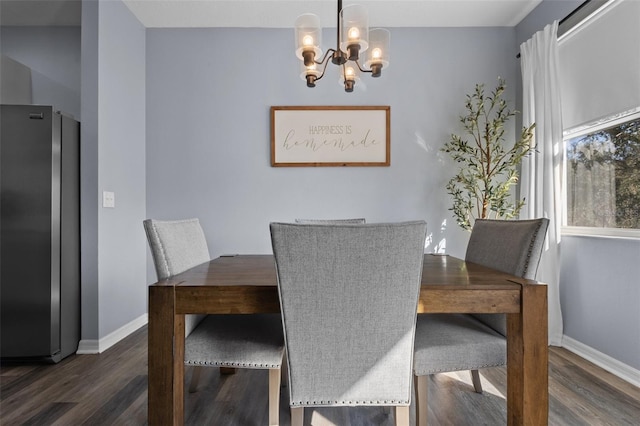 dining room with dark hardwood / wood-style flooring and a chandelier