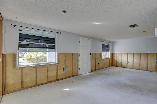 unfurnished room with a textured ceiling