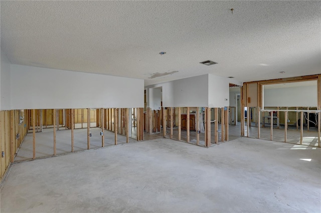 miscellaneous room featuring concrete flooring and a textured ceiling