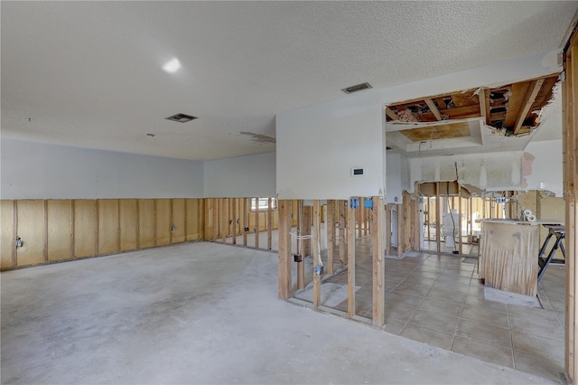 basement with wooden walls and a textured ceiling