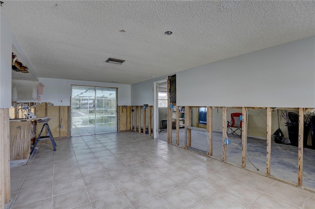 interior space with light tile patterned floors and a textured ceiling