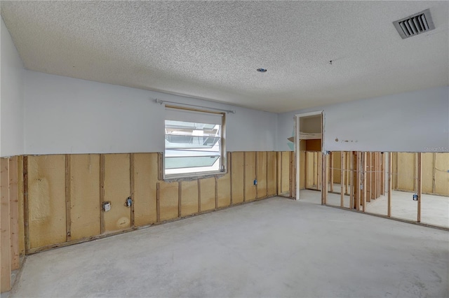 unfurnished room featuring a textured ceiling