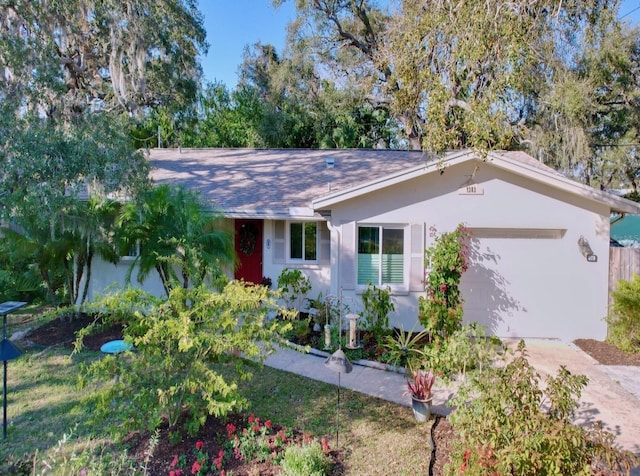 ranch-style home with a garage, concrete driveway, and stucco siding